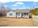 Charming single-story home with gray siding, blue shutters, covered porch and a well-maintained front yard at 1033 Forest Glen Dr, Raleigh, NC 27603
