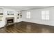 Bright living room with a brick fireplace, built-in shelving, hardwood floors, and plantation shutters at 104 Province Cir, Rocky Mount, NC 27804