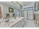 Well-lit bathroom boasts double sinks, a large mirror, and a shower with glass doors, all decorated in a patterned motif at 106 Legault Dr, Cary, NC 27513