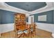 Elegant dining room with dark blue walls, hardwood floors, and a large china cabinet at 106 Legault Dr, Cary, NC 27513