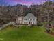 Stately two-story home features a lush green lawn, mature trees, and welcoming front porch, perfect for Gathering living at 106 Legault Dr, Cary, NC 27513