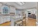 Bright kitchen features granite countertops, white cabinets, island with seating, and view of the living room at 106 Legault Dr, Cary, NC 27513