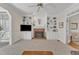 Living room with a brick fireplace, built-in shelves, a ceiling fan, and a view through to the kitchen at 106 Legault Dr, Cary, NC 27513