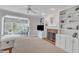 Living room boasts a brick fireplace, built-in shelving, a ceiling fan, and a view of the sunroom at 106 Legault Dr, Cary, NC 27513