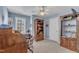 Blue office featuring a large window, ceiling fan and a wooden desk with ample storage space at 106 Legault Dr, Cary, NC 27513