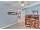 Cozy blue home office with a vintage desk, ceiling fan, and decor that provides workspace with charm at 106 Legault Dr, Cary, NC 27513