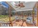 Relaxing screened porch with a ceiling fan and comfortable seating overlooking a lush landscape at 106 Legault Dr, Cary, NC 27513