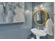 Stylish powder room with blue walls, modern fixtures, and an elegant gold-trimmed mirror at 106 Legault Dr, Cary, NC 27513