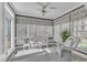 Cozy sunroom filled with natural light, white wicker furniture, a ceiling fan, and verdant backyard views at 106 Legault Dr, Cary, NC 27513
