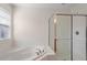 Full bathroom with a soaking tub, a separate shower, and white tiled walls at 110 Darley Dale Loop, Apex, NC 27502