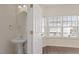 Bright powder room with pedestal sink, round mirror and a window letting in lots of natural light at 110 Darley Dale Loop, Apex, NC 27502