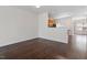 Spacious living room featuring hardwood floors, a partial wall, and a view into the kitchen at 110 Darley Dale Loop, Apex, NC 27502