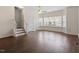 Well-lit living room showcasing wood floors, a ceiling fan, and staircase access to the upper level at 110 Darley Dale Loop, Apex, NC 27502