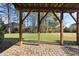 Covered outdoor patio with brick flooring overlooking the green backyard with mature trees at 1104 Fanning Dr, Wake Forest, NC 27587