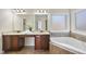 Well-lit bathroom featuring double sinks, a soaking tub, and tile flooring at 1104 Fanning Dr, Wake Forest, NC 27587