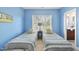 Charming bedroom featuring bright blue walls, twin beds, natural light, and view to a bathroom at 1104 Fanning Dr, Wake Forest, NC 27587