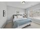 Cozy bedroom featuring soft gray walls, plush bedding, side table, and window at 1104 Fanning Dr, Wake Forest, NC 27587