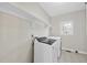 Well-lit laundry room featuring tile flooring, white washer/dryer, and shelving for storage at 1104 Fanning Dr, Wake Forest, NC 27587