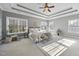 Bright main bedroom showcasing tray ceilings, a ceiling fan, and large windows at 1104 Fanning Dr, Wake Forest, NC 27587