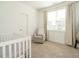 Bright Bedroom with a white crib, cozy chair, and large window with natural light at 120 Wise Oak Ln, Garner, NC 27529