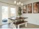 Bright dining area with a rustic wood table, bench seating, and sliding glass doors at 120 Wise Oak Ln, Garner, NC 27529