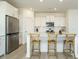 Bright kitchen featuring stainless steel appliances, quartz countertops, white cabinets, and barstool seating at 120 Wise Oak Ln, Garner, NC 27529