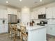 Open kitchen with an island, stainless steel appliances, white cabinets, and barstool seating at 120 Wise Oak Ln, Garner, NC 27529