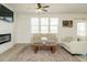 Bright living room featuring a fireplace, ceiling fan, and modern decor at 120 Wise Oak Ln, Garner, NC 27529