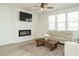 Bright living room featuring a fireplace, ceiling fan, and modern decor at 120 Wise Oak Ln, Garner, NC 27529