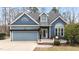 Charming blue two-story home with a neatly kept lawn and inviting front porch at 1217 Hillingdon Way, Raleigh, NC 27614