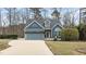 Charming blue home featuring an attached garage, manicured lawn, and beautiful curb appeal at 1217 Hillingdon Way, Raleigh, NC 27614