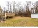 View of large backyard featuring wooden deck, mature trees, and storage shed at 12491 Buffalo Rd, Archer Lodge, NC 27527