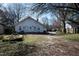 A backyard view of a well-maintained house with a driveway in a serene, wooded setting at 1805 Shelton Ave, Durham, NC 27707
