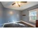Neutrally painted bedroom featuring hardwood floors, a ceiling fan, and a window letting in lots of natural light at 1805 Shelton Ave, Durham, NC 27707