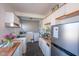 Kitchen area with white cabinets, double sinks, laundry equipment, and stainless refrigerator at 1805 Shelton Ave, Durham, NC 27707