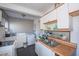 Kitchen area with white cabinets, double sinks, laundry equipment, and view to the backyard at 1805 Shelton Ave, Durham, NC 27707