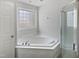 Bright white bathroom featuring soaking tub and enclosed shower stall at 20 Beechnut Ct, Franklinton, NC 27525