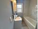 Bathroom with modern vanity, grey walls, a tub, and natural lighting at 201 W Thorndale Dr, Oxford, NC 27565