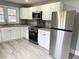 Bright kitchen featuring stainless steel appliances, granite countertops, and white cabinets at 201 W Thorndale Dr, Oxford, NC 27565