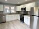 Bright kitchen featuring white cabinets, granite countertops, and stainless steel appliances at 201 W Thorndale Dr, Oxford, NC 27565