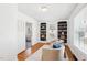 Bright living area with hardwood floors, built-in bookshelves, plush seating, and open doorway offering a versatile space at 202 W Lavender Ave, Durham, NC 27704