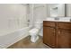 Cozy bathroom with white tub, toilet, and brown vanity cabinet at 265 Freeman Pines Pl, Fuquay Varina, NC 27526
