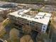 Aerial view of a four-story apartment building featuring brick facade, rooftop equipment, and private balconies at 300 Finsbury St # 313, Durham, NC 27703