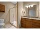Bathroom with granite countertops, wooden cabinets, and walk-in shower with glass doors at 300 Finsbury St # 313, Durham, NC 27703