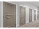 Hallway view featuring numbered unit doors with white trim and neutral carpet in a shared living space at 300 Finsbury St # 313, Durham, NC 27703