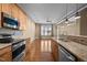 Bright kitchen featuring stainless steel appliances, granite countertops, and hardwood flooring throughout the open concept at 300 Finsbury St # 313, Durham, NC 27703