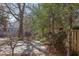 Backyard featuring a stone patio, mature trees, lush landscaping, and wood fence at 300 Mccauley St, Chapel Hill, NC 27516
