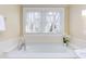 Relaxing bathroom showcasing a soaking tub with chrome fixtures and natural light from a window at 300 Mccauley St, Chapel Hill, NC 27516