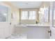 Bright bathroom featuring marble floors, soaking tub, and classic fixtures at 300 Mccauley St, Chapel Hill, NC 27516