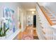 Bright entryway features hardwood floors, white trim, staircase and view to laundry room at 300 Mccauley St, Chapel Hill, NC 27516